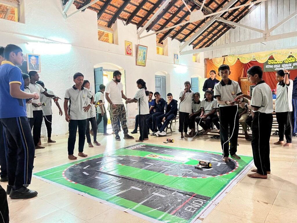 Students testing their RC cars on a track as part of the robotics workshop at Government High School, Virajpet